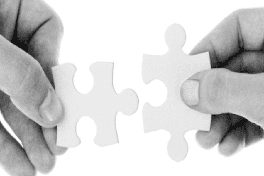 two hands putting puzzle pieces together